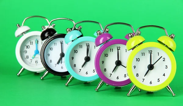 Colorful alarm clock on green background — Stock Photo, Image