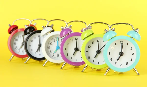 Reloj despertador colorido sobre fondo amarillo —  Fotos de Stock