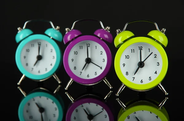 Colorful alarm clock on dark grey background