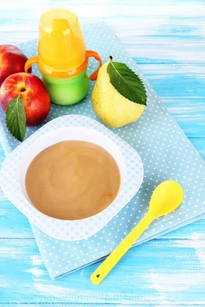 Leckeres Babyfruchtpüree und Babyflasche auf Holztisch — Stockfoto