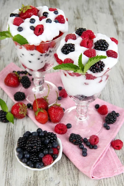 Přírodní jogurt s čerstvým ovocem na dřevěné pozadí — Stock fotografie