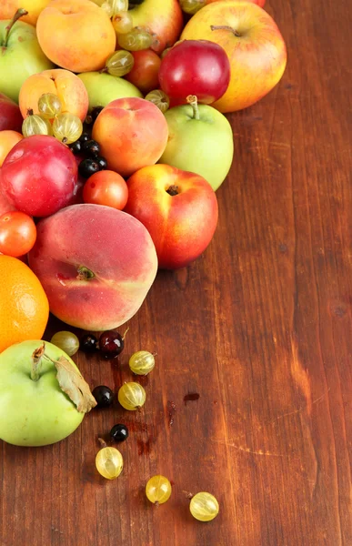 Surtido de frutas jugosas, sobre fondo de madera — Foto de Stock