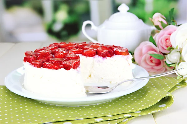 Cheesecake med färska jordgubbar på vit platta på träbord — Stockfoto