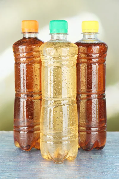 Ассортимент бутылок с вкусными напитками, на ярком фоне — стоковое фото