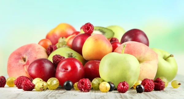Ассортимент сочных фруктов, на деревянном столе, на ярком фоне — стоковое фото