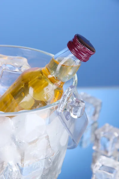 Bottiglie minibar in secchio con cubetti di ghiaccio, su sfondo colore — Foto Stock