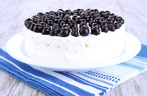 Tarta de queso con bayas frescas en plato blanco en primer plano de mesa de madera —  Fotos de Stock