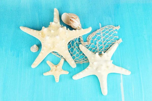 Mavi ahşap masa yakın çekim üzerinde beyaz starfishes — Stok fotoğraf