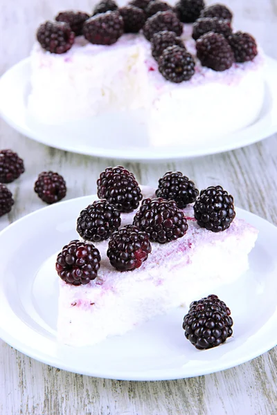 Cheesecake with fresh berries on white plate on wooden table closeup — Stock Photo, Image