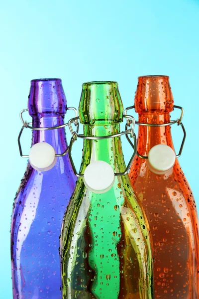 Colorful bottles on light blue background — Stock Photo, Image