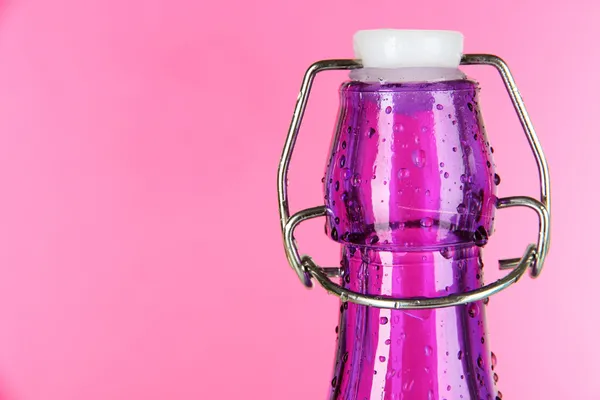 Barevná láhev na růžovém pozadí — Stock fotografie