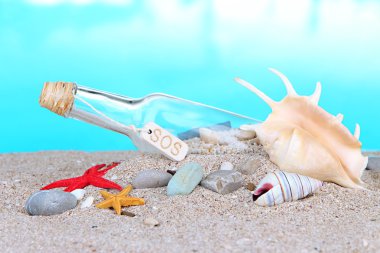 cam şişe içinde not parlak mavi arka plan ile