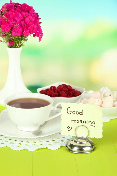 Hermoso ramo de flox con taza de té en la mesa sobre fondo claro — Foto de Stock