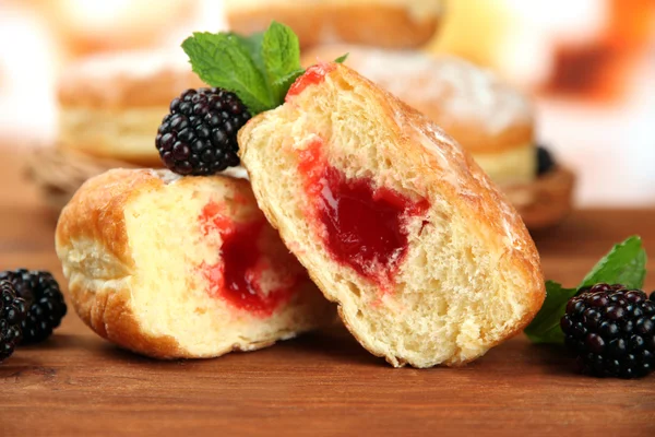 Leckere Donuts mit Beeren auf Holztisch — Stockfoto