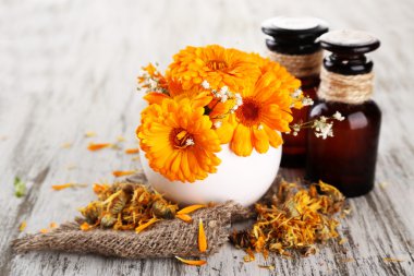 ilaç şişeleri ve ahşap zemin üzerine calendula çiçekler