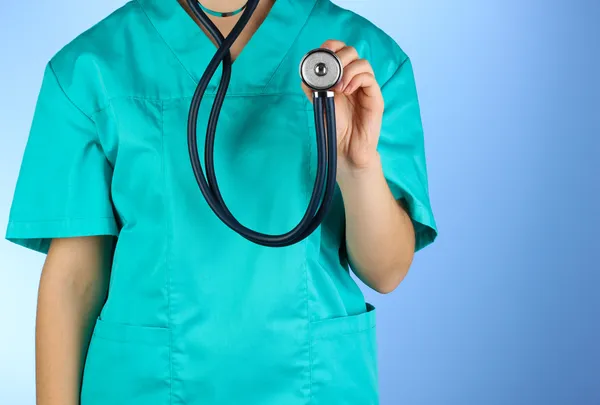 Lekarz za pomocą stetoskopu na niebieskim tle — Zdjęcie stockowe