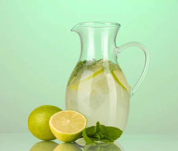 Lemonade in pitcher on turquoise background — Stock Photo, Image
