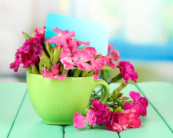 Bouquet d'oeillets, sur table en bois couleur, sur fond lumineux — Photo