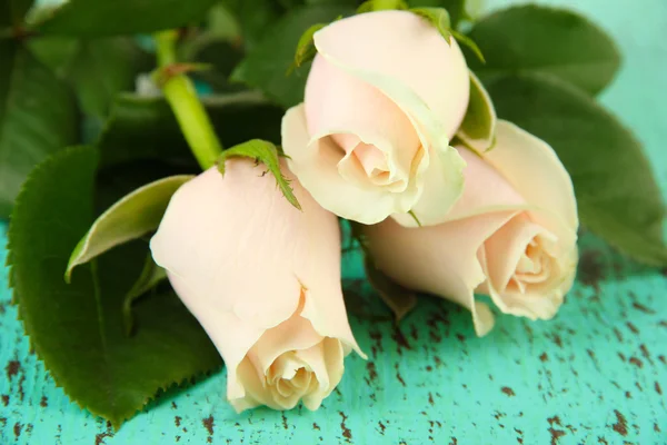 Hermosas rosas, sobre fondo de madera de color — Foto de Stock