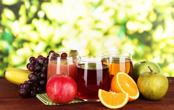 Glasses of fresh juice on table on bright background — Stock Photo, Image