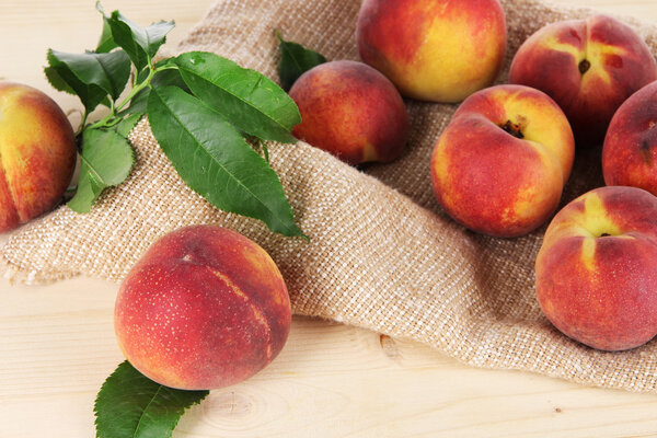 Peaches on sackcloth on wooden table