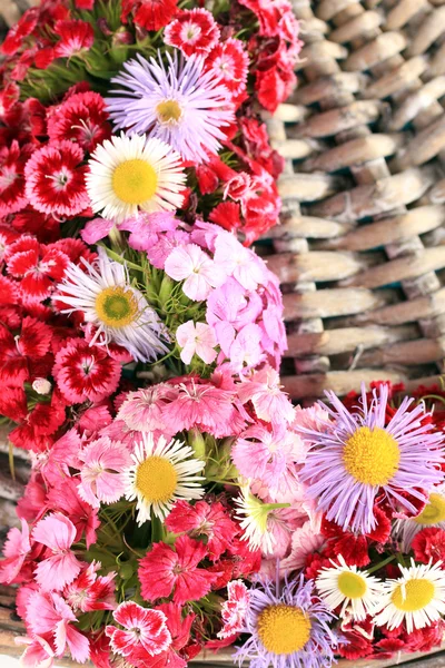 Flores silvestres sobre fondo de madera de mimbre —  Fotos de Stock