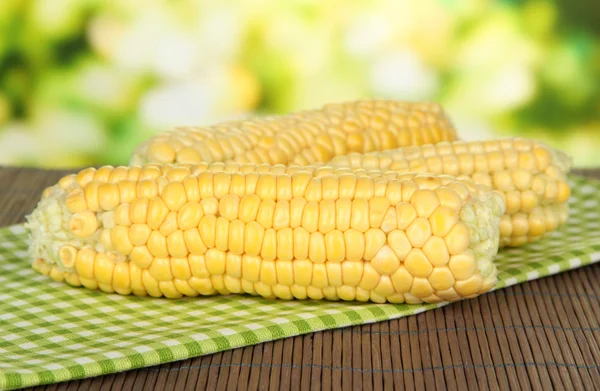 Fresh corn on bamboo mat, on bright background — Stock Photo, Image