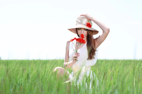 Portret pięknej młodej kobiety z maku w polu — Zdjęcie stockowe