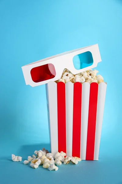 Palomitas de maíz y gafas 3D sobre fondo azul —  Fotos de Stock