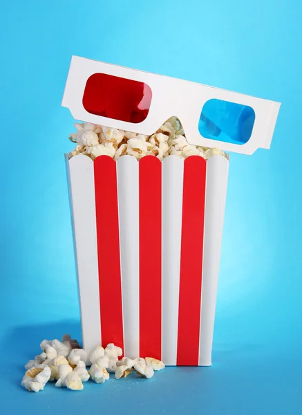 Popcorn und 3D-Brille auf blauem Hintergrund — Stockfoto