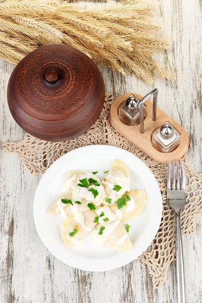 Leckere Knödel mit gebratener Zwiebel auf weißem Teller, auf Holzgrund — Stockfoto