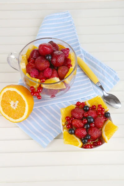 Insalata di frutta utile in tazza di vetro e ciotola sul tavolo di legno primo piano — Foto Stock