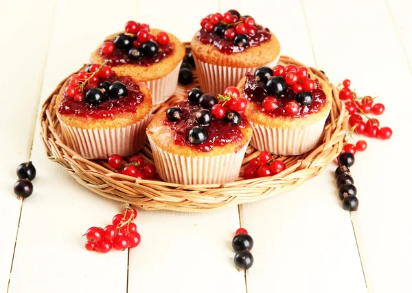 Smakelijke muffins met bessen op witte houten tafel — Stockfoto