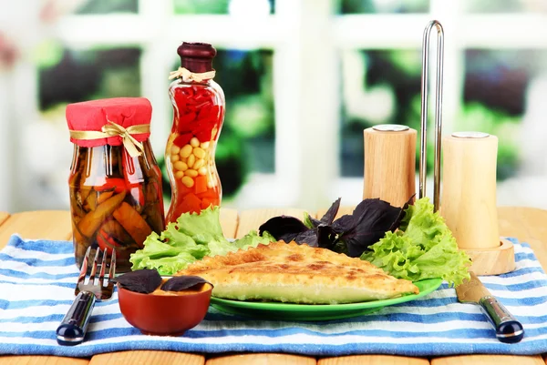 Sabrosos chebureks con hierbas frescas en el plato, en la mesa de madera, sobre fondo brillante — Foto de Stock