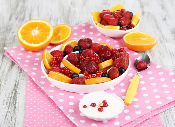 Nützlicher Obstsalat in Tellern auf Holztisch in Großaufnahme — Stockfoto