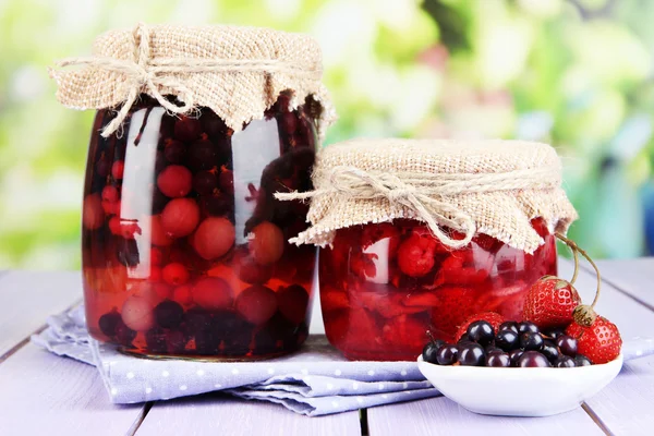 Hausgemachte Beerenmarmelade auf Holztisch auf hellem Hintergrund — Stockfoto