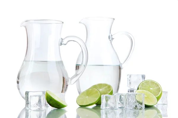 Jarras de vidrio de agua con hielo y cal aisladas en blanco —  Fotos de Stock