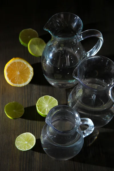 Jarros de vidro de água em mesa de madeira close-up — Fotografia de Stock