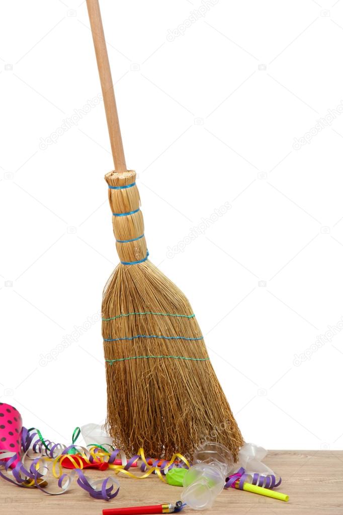 Broom sweep the trash after a party on white background close-up