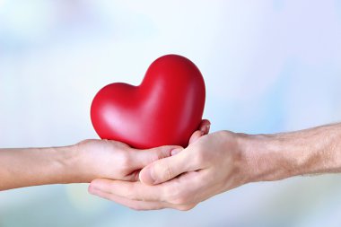 Işık arkaplanındaki kalp ellerinde