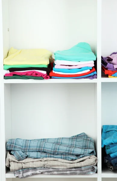 Clothes neatly folded on shelves — Stok fotoğraf