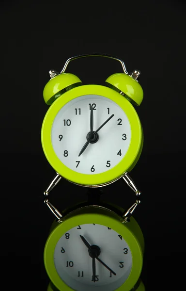 Reloj despertador verde sobre fondo gris oscuro —  Fotos de Stock