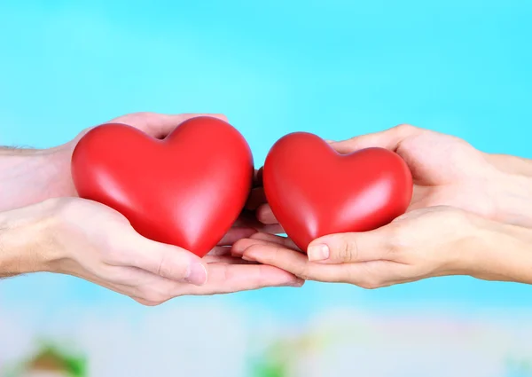Hearts in hands on cloud background — Stock Photo, Image