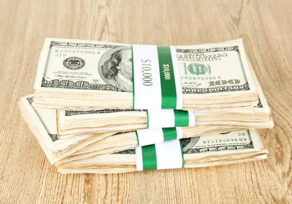 Hromádky peněz na dřevěném stole — Stock fotografie
