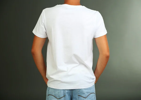 T-shirt em jovem, em fundo cinza — Fotografia de Stock