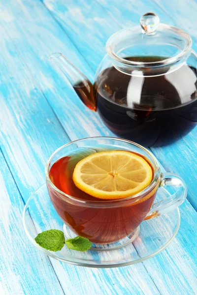 Taza de té con limón sobre la mesa sobre fondo azul — Foto de Stock