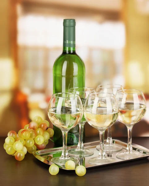 Vino bianco in vetro e bottiglia su sfondo camera — Foto Stock