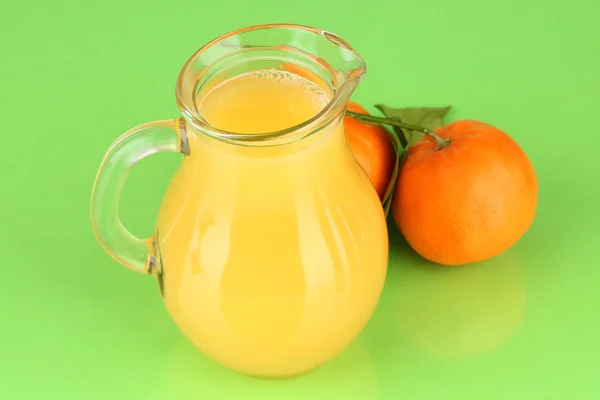 Полный кувшин апельсинового сока, на деревянном столе на ярком фоне — стоковое фото