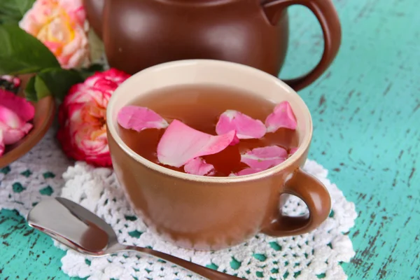 Wasserkocher und Tasse Tee aus Teerose an Bord auf Serviette auf Holzgrund — Stockfoto