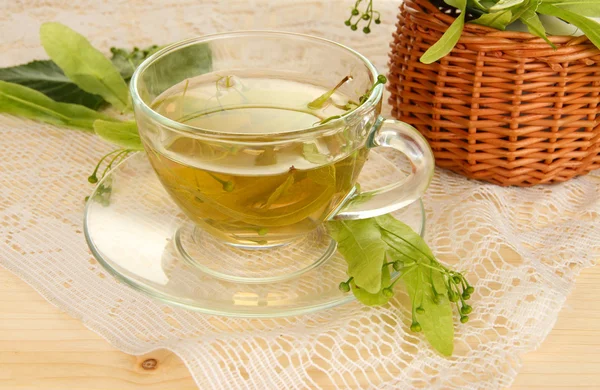 Glass cup of tea with linden on wooden table close-up — Stock Photo, Image